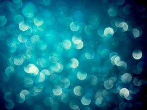 An abstract background featuring a vibrant array of blue and teal bokeh lights. The blurred circular patterns create a soft, glowing effect, evoking a sense of tranquility and depth.