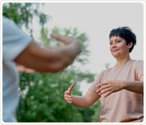 Two individuals practicing Qigong outdoors, focusing on mindful movements and energy flow amidst a serene natural setting.