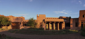 Exterior view of the Southwest Sanctuary at sunset, showcasing its serene adobe architecture surrounded by natural beauty, a perfect space for healing and meditation.