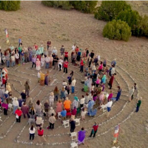 Aerial view of a community gathering in a stone labyrinth at The Chi Center, symbolizing unity, meditation, and shared healing practices in a serene desert landscape