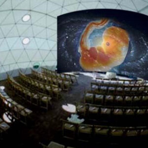 Interior of the Chi Center Dome featuring a unique presentation setup with a cosmic-themed projection of an embryo, surrounded by rows of chairs in a peaceful and inspiring environment.
