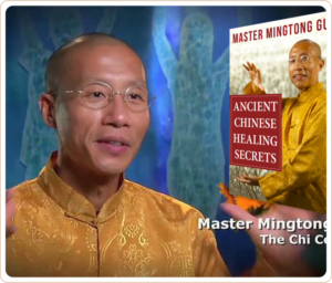 Master Mingtong Gu wearing a golden robe, sharing insights during an interview with a backdrop of healing energy figures, alongside an image of his book titled 'Ancient Chinese Healing Secrets.