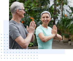 Senior man and woman practicing mindfulness and yoga together outdoors in a lush green garden, symbolizing health, connection, and wellness.