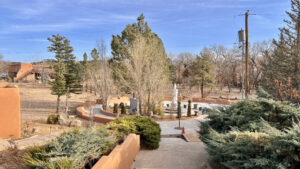 Serene view of The Chi Center's Lotus Garden, featuring a peaceful pathway, vibrant greenery, and the statue of Guan Yin amidst a tranquil landscape under a clear blue sky.