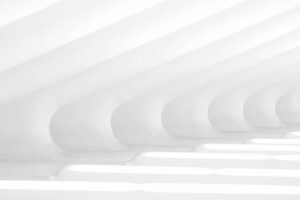 Minimalistic architectural design with curved white beams creating a clean and futuristic pattern, bathed in soft natural light.