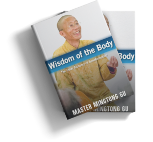 Book cover for 'Wisdom of the Body: The Inner Alchemy of Transformation' by Master Mingtong Gu, featuring a smiling Master Mingtong Gu in a yellow traditional outfit.