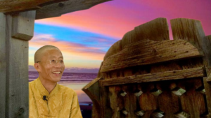 Master Mingtong Gu beside a Rustic wooden gate frame with vibrant hues of a pink and blue sunset in the background, symbolizing tranquility and connection to nature.
