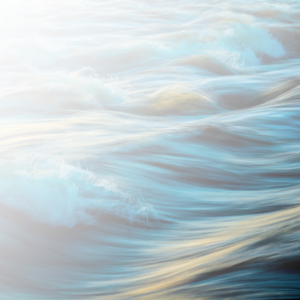 Flowing water with soft ripples and golden light reflections, symbolizing movement, serenity, and natural harmony.