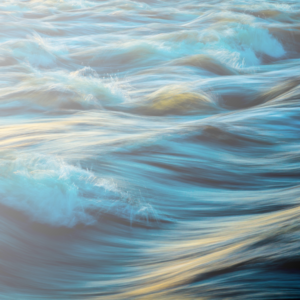 Flowing water with soft ripples and golden light reflections, symbolizing movement, serenity, and natural harmony.