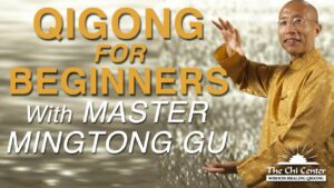 Promotional image for 'Qigong for Beginners with Master Mingtong Gu,' featuring Master Mingtong Gu in a gold traditional Chinese outfit, gesturing gracefully, with The Chi Center logo and a serene, blurred background.