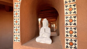 White Buddha Statue in Alcove Surrounded by Decorative Tiles at The Serenity Center