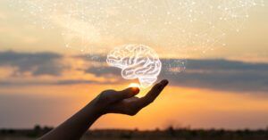 Hand holding a graphic of a brain