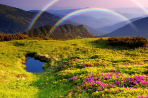 Scenic mountain landscape with vibrant green meadows, blooming pink flowers, a tranquil pond, and double rainbows arching across a serene purple-hued sky.