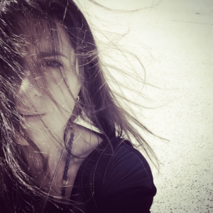 Artistic black-and-white portrait of Martha Reich with wind-blown hair, capturing a soulful and introspective moment.