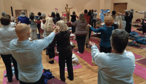 Group practicing Qigong in the kiva, guided by Master Mingtong Gu, fostering collective energy healing, mindfulness, and inner balance.