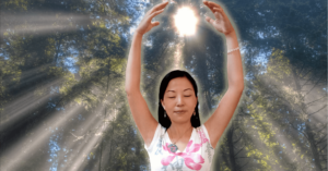 Linling practicing Qigong in a serene forest setting with sunlight streaming through the trees, embodying tranquility and connection with nature.