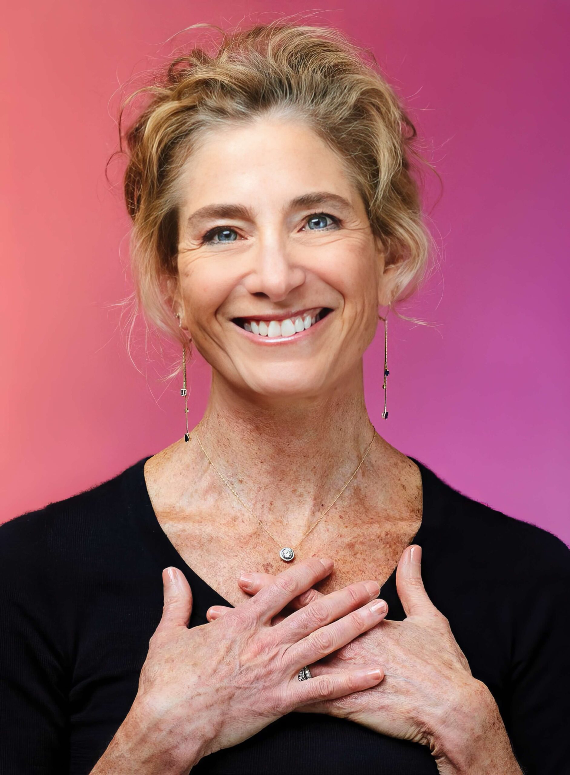 Tara Brach smiling warmly, hands placed over her heart