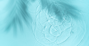 Close-up view of tranquil water ripples in a teal blue pond, symbolizing the calming source energy of Hun Yuan Chi. This image captures the essence of stillness and flow, reflecting the principles of Wisdom Healing Qigong and sound healing in its serene water patterns.