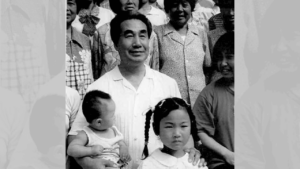 Dr. Pang surrounded by children in a black-and-white group photo, reflecting his connection to community and his dedication to sharing Qigong.