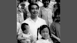 Dr. Pang surrounded by children in a black-and-white group photo, reflecting his connection to community and his dedication to sharing Qigong.