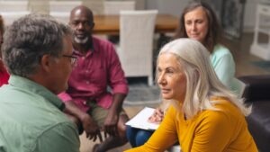 Engaged group of diverse adults participating in a meaningful conversation during a support or discussion circle in a cozy indoor setting.