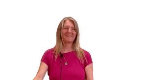 Smiling woman with long blonde hair wearing a magenta shirt and pendant necklace, speaking or presenting with a microphone headset