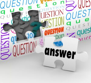 A conceptual illustration shows puzzle pieces fitting together, with one white piece labeled “answer” connecting to a darker piece with a question mark. The background is filled with the word “question” repeated in many colors and fonts, symbolizing problem-solving and finding answers.